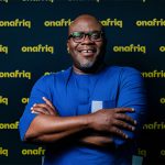 African woman using a smartphone and bank card for digital payments in DR Congo